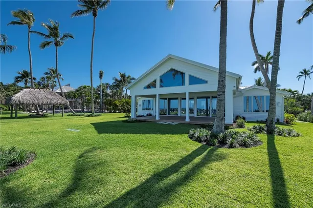 a view of a house with a big yard and large trees