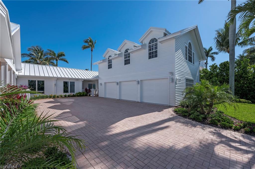 71 18th Avenue South Naples, FL 34102 - Photo 8 of 50 a front view of a house with a yard and garage