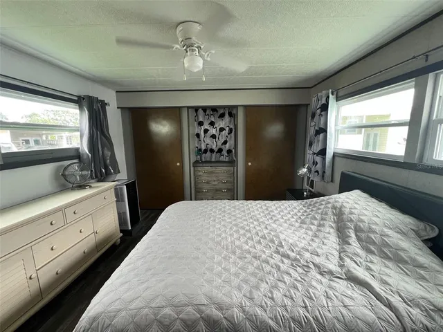 a spacious bedroom with a large bed and dresser with mirror