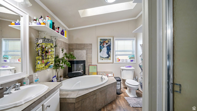 490 South Main Street Kamas, UT 84036 - Photo 7 of 25 Bathroom featuring a built-in soaking tub with a tiled surround, a vanity with dual sinks and a framed mirror, wood-finish flooring, a skylight, and a separate shower enclosure
