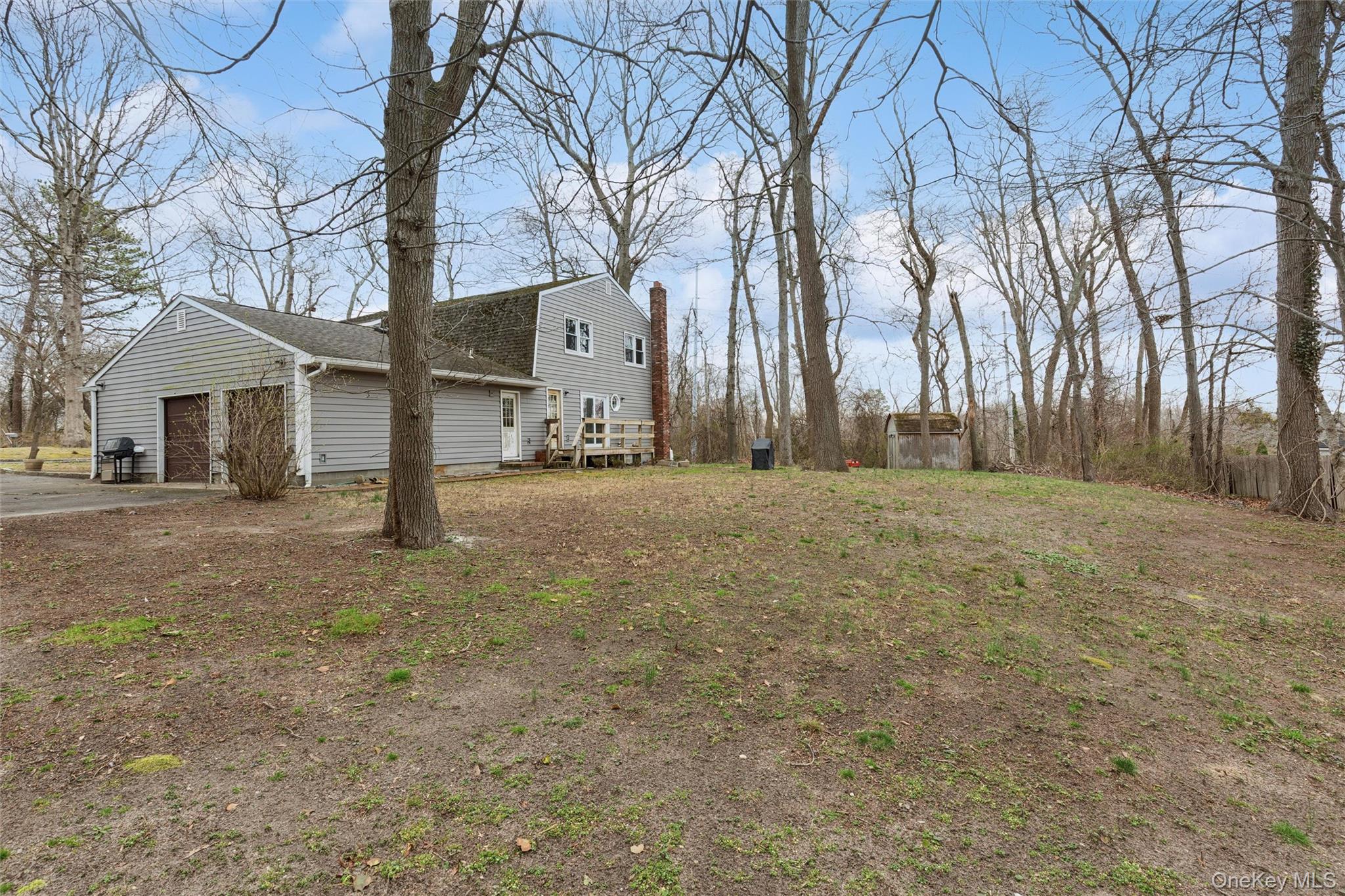 49 Overhill Road Wading River, NY 11792 - Photo 25 of 27 a backyard of a house with large trees