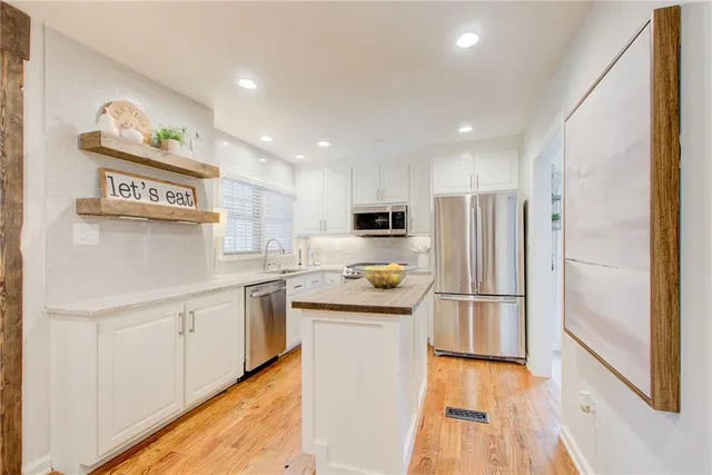 a kitchen with stainless steel appliances granite countertop a refrigerator and a stove top oven