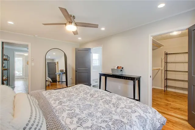 a bedroom with a bed and a dresser with mirror