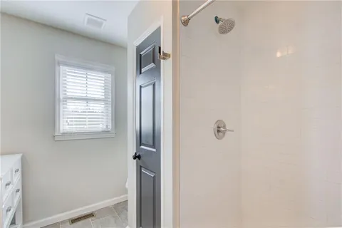 a bathroom with a window and a shower