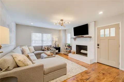 a living room with furniture a fireplace and a flat screen tv