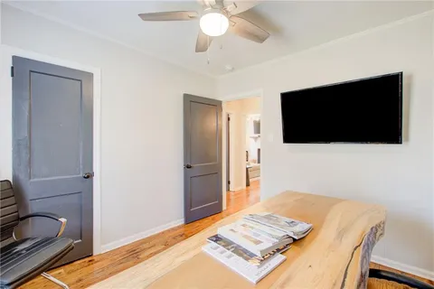 a living room with a flat screen tv and a refrigerator