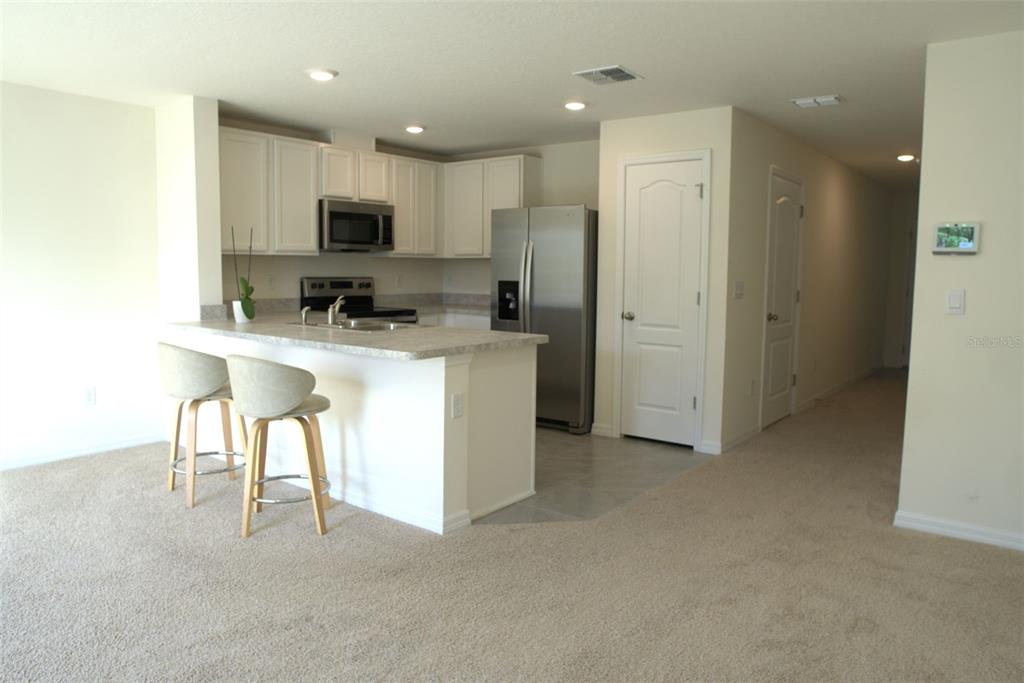 4079 Malawi Trail St. Cloud, FL 34772 - Photo 6 of 19 a view of kitchen with refrigerator stove microwave oven and cabinets