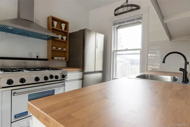 a kitchen with stainless steel appliances a sink a stove and a refrigerator