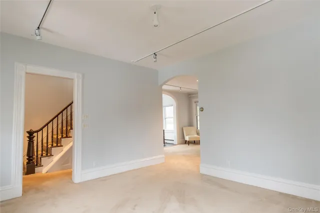 a view of a hallway to a room with wooden floor and fence