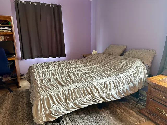 a bed sitting in a bedroom next to a cabinet