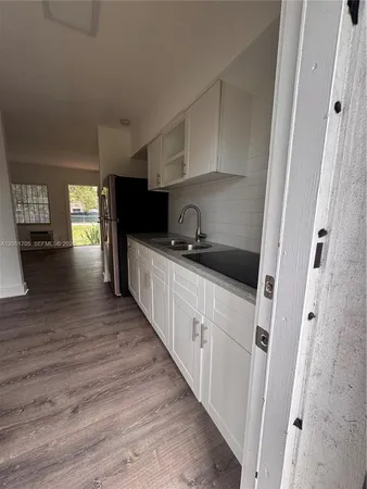 a kitchen with granite countertop a sink and cabinets
