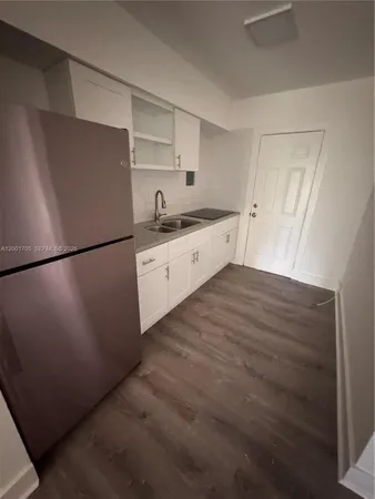 a kitchen with granite countertop white cabinets and white appliances