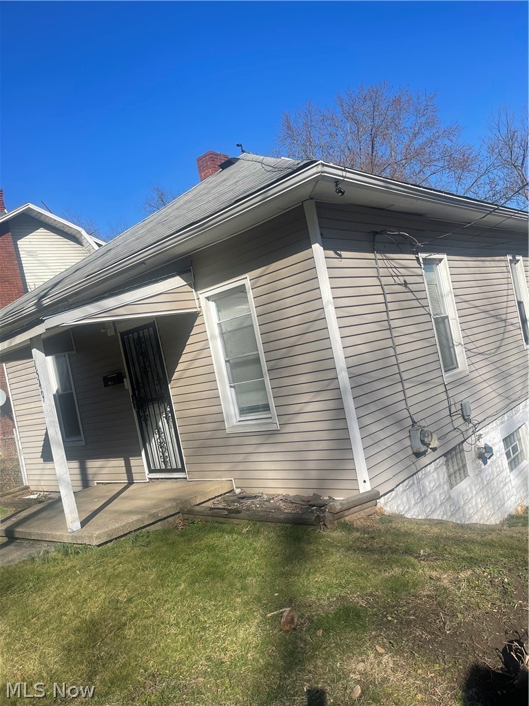 View of side of home featuring a yard