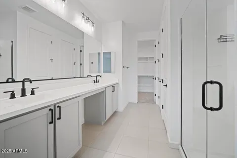 a spacious bathroom with a shower sink and mirror