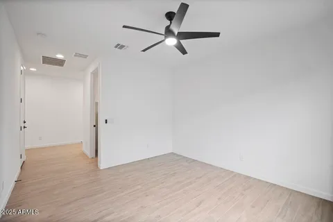 a view of a room with wooden floor and a ceiling fan
