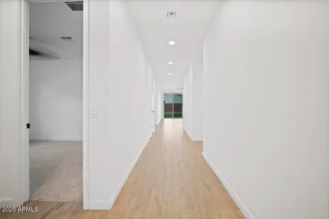 a view of a hallway with wooden floor