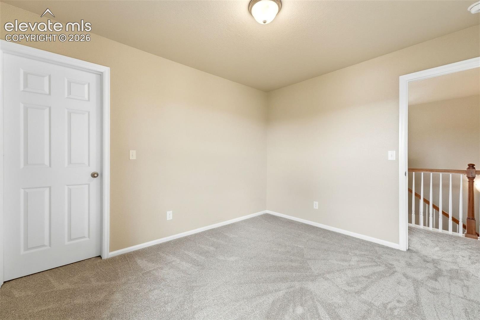 7274 Red Cardinal Loop Colorado Springs, CO 80908 - Photo 16 of 33 Neutral wall tones, ceiling-mounted light fixture, white interior door, light-colored carpet, and a framed doorway