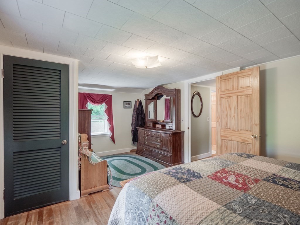 39 Echo Street Melrose, MA 02176 - Photo 16 of 32 a bedroom with a bed and dresser with mirror