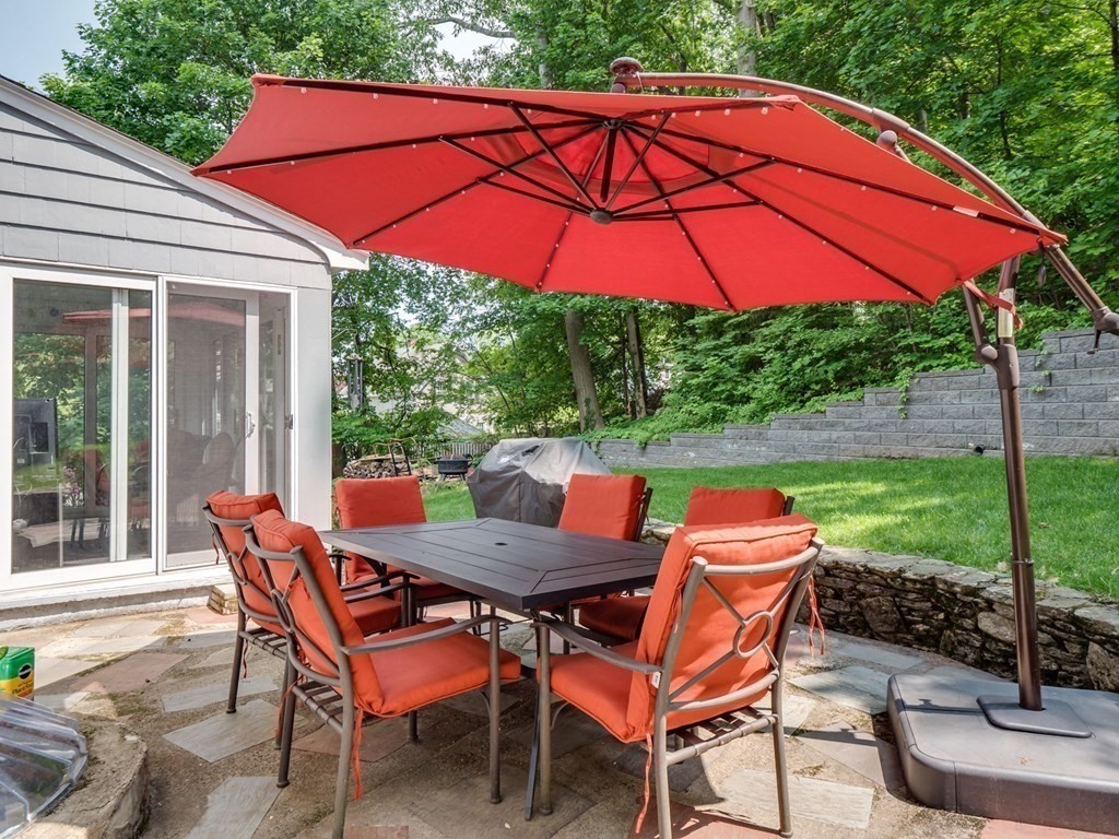 39 Echo Street Melrose, MA 02176 - Photo 26 of 32 a patio with a table and chairs under an umbrella