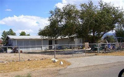 22616 Sitting Bull Road Apple Valley, CA 92308 - Photo 1 of 1 a backyard of a house with table and chairs and potted plants with large tree