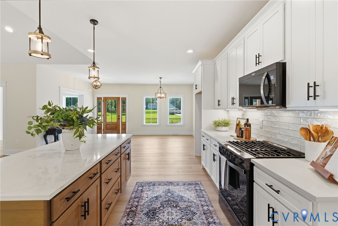 7376 River Road Hanover, VA 23069 - Photo 11 of 46 a kitchen with stainless steel appliances granite countertop a sink a stove and a wooden floors