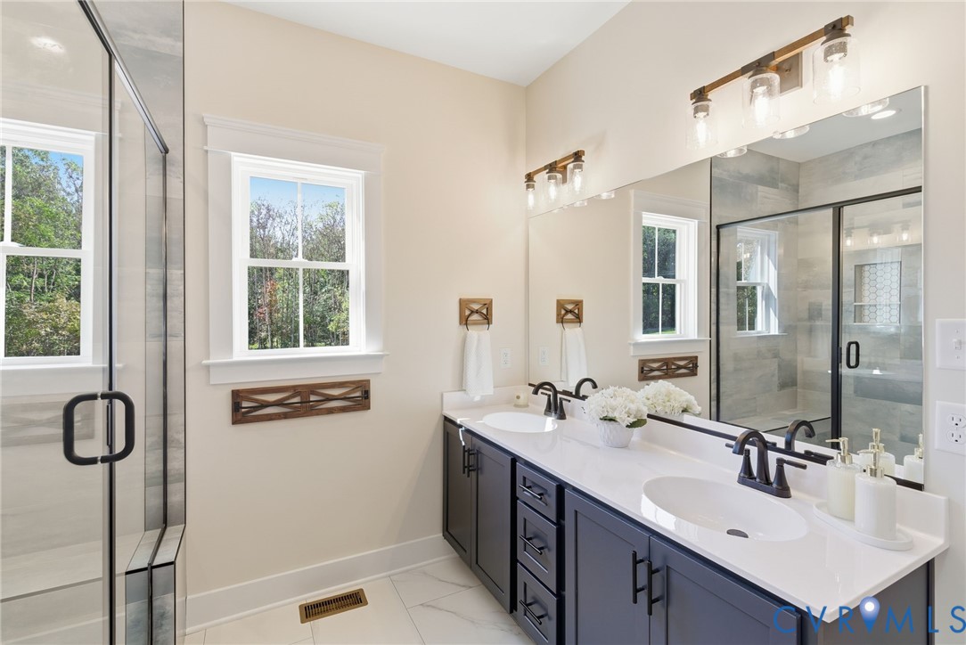 7376 River Road Hanover, VA 23069 - Photo 32 of 46 a bathroom with a double vanity sink a mirror and a shower