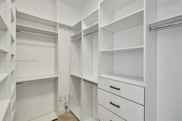 a view of walk in closet with empty racks