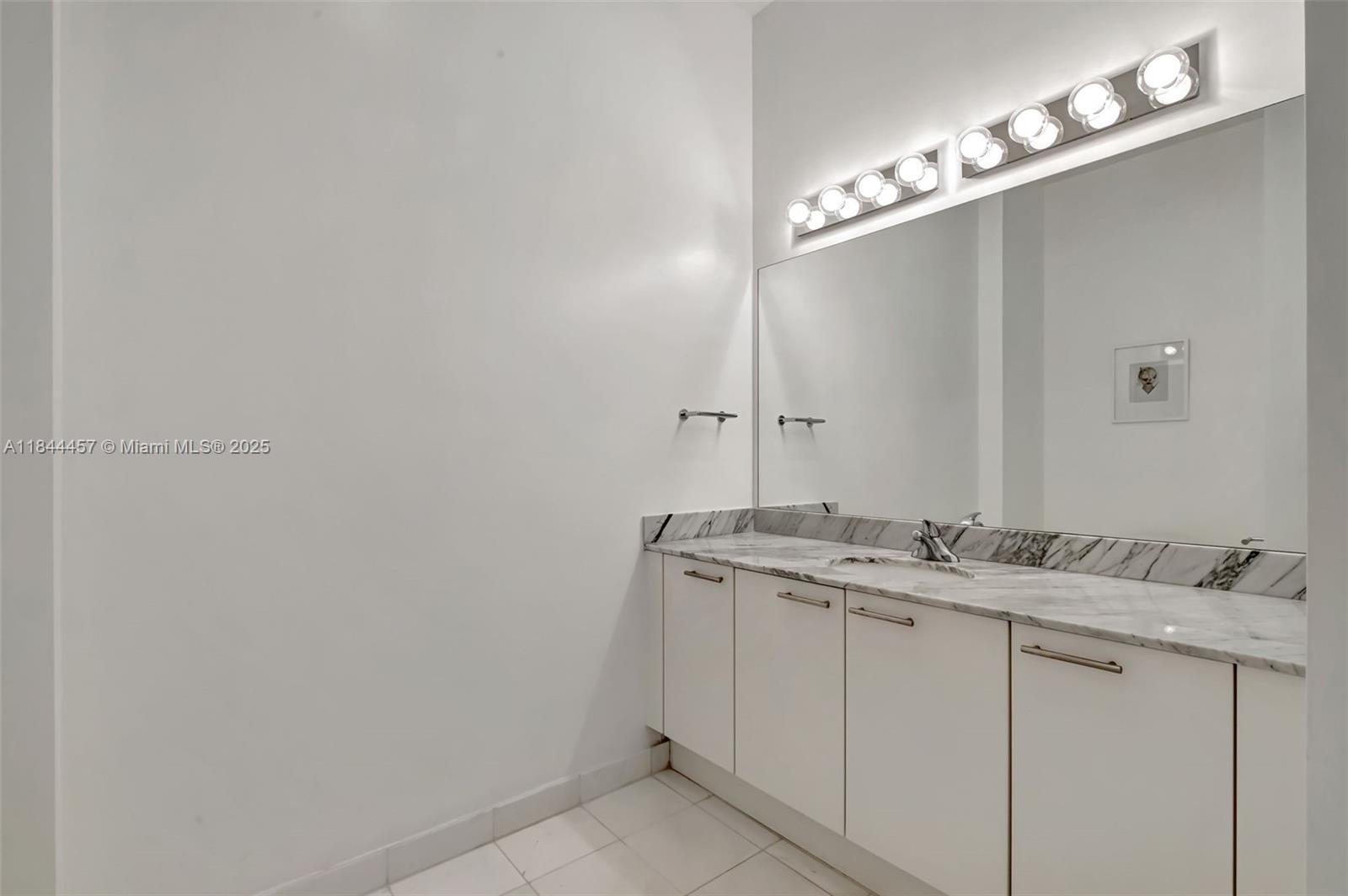 2001 Meridian Avenue, Unit PH15 Miami Beach, FL 33139 - Photo 13 of 31 a bathroom with a granite countertop sink and a mirror