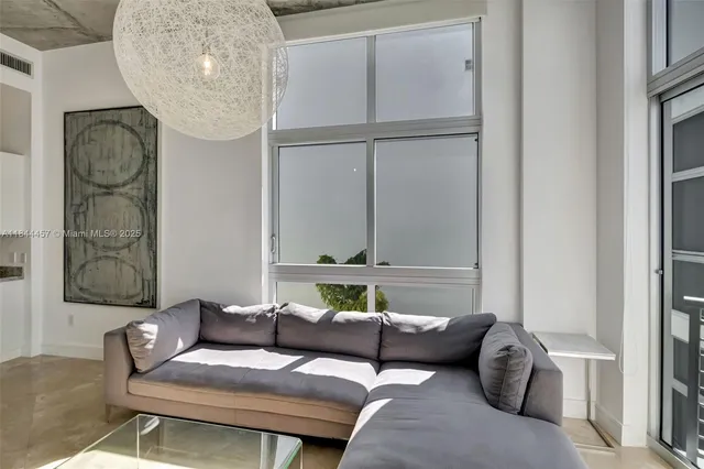 a living room with furniture and a painting on the wall