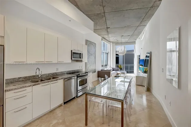 a kitchen with stainless steel appliances granite countertop a sink a stove counter space and cabinets
