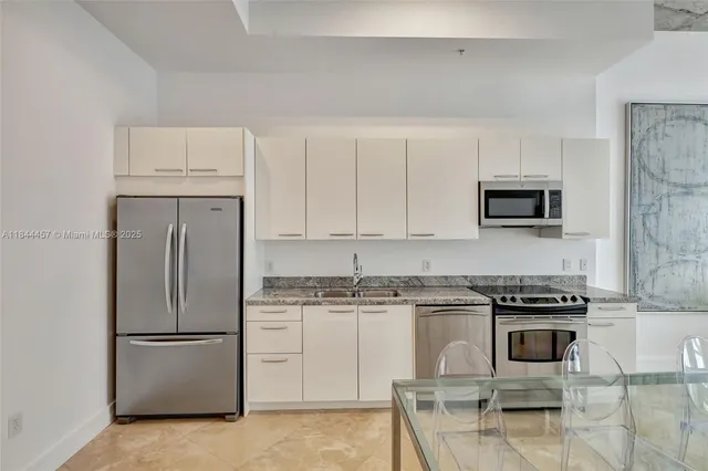 a kitchen with white cabinets and stainless steel appliances