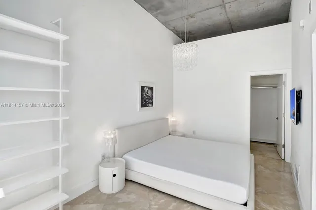 a spacious bedroom with a bed and a window