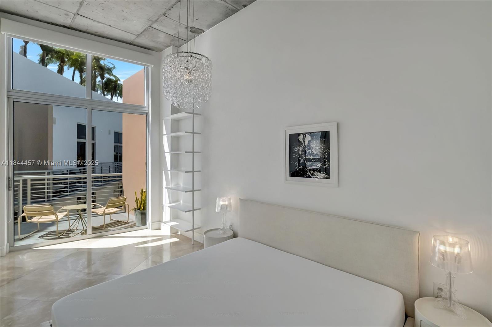 2001 Meridian Avenue, Unit PH15 Miami Beach, FL 33139 - Photo 10 of 31 a bedroom with a bed and a chandelier