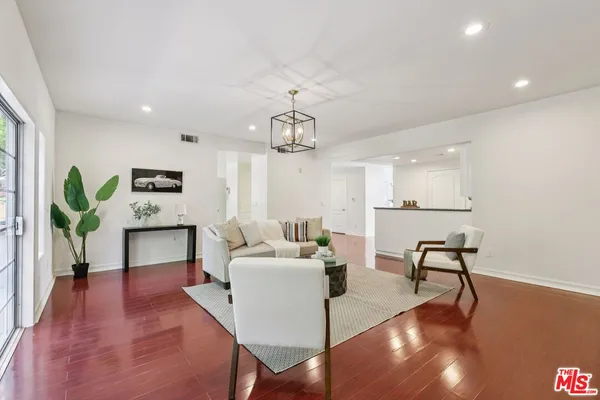 a living room with furniture a dining table and a potted plant
