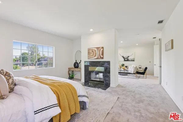 a spacious bedroom with a bed and a fireplace