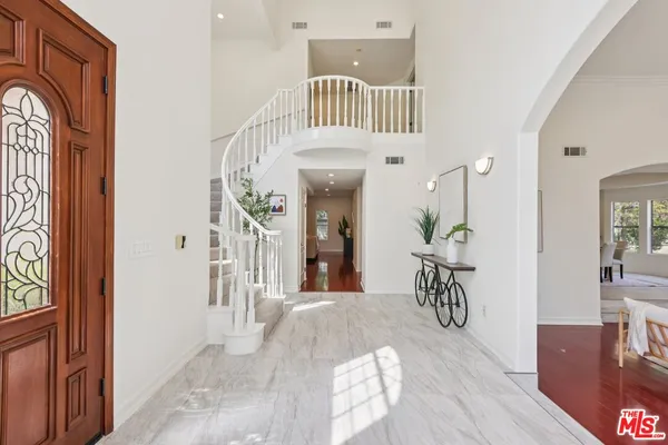 a view of a hallway with wooden floor and windows