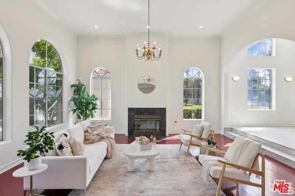 a living room with furniture a fireplace and a chandelier