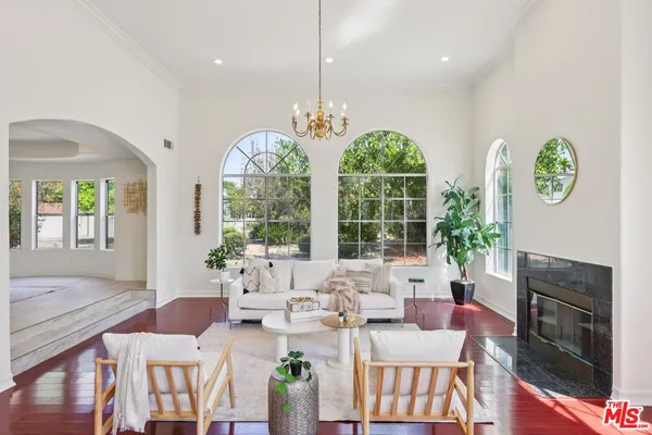a living room with furniture a fireplace and a chandelier