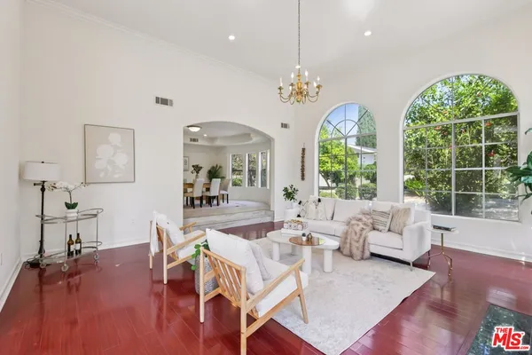 a view of a dining room with furniture a chandelier and wooden floor