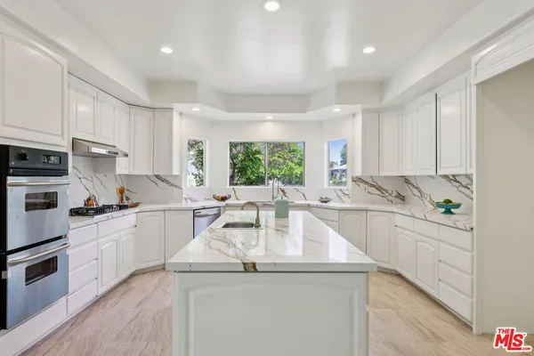 a kitchen with stainless steel appliances granite countertop a sink and cabinets