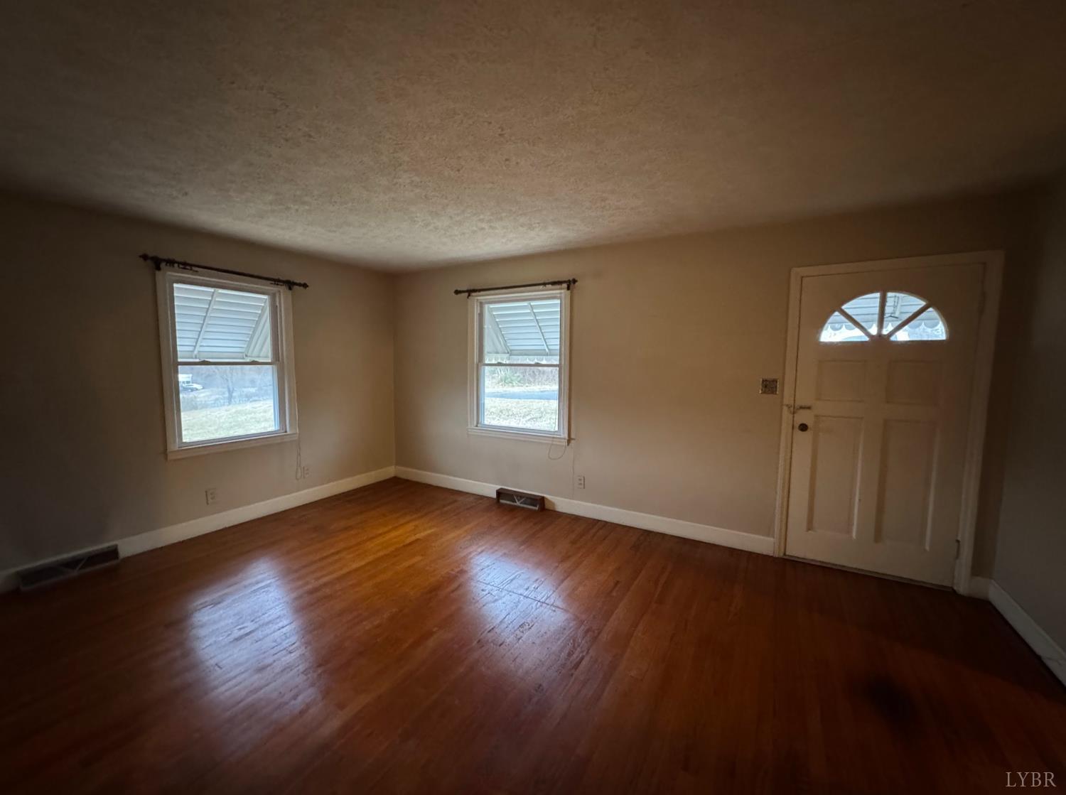 126 Rothwood Road Monroe, VA 24574 - Photo 11 of 21 an empty room with wooden floor and windows