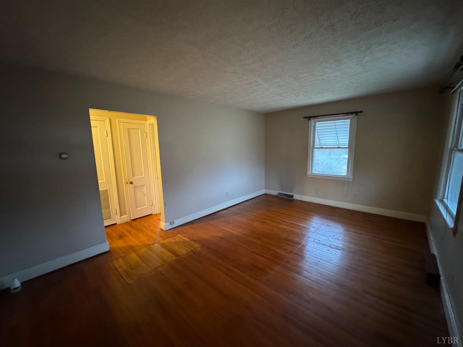 126 Rothwood Road Monroe, VA 24574 - Photo 12 of 21 an empty room with wooden floor and windows