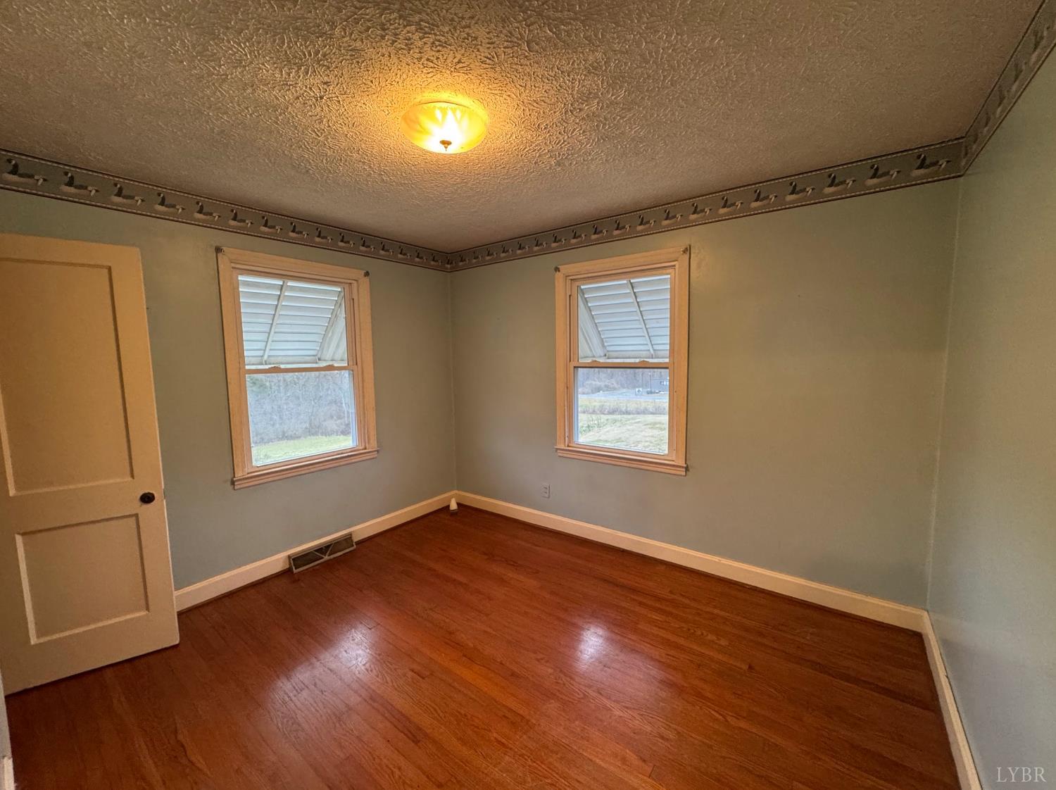 126 Rothwood Road Monroe, VA 24574 - Photo 10 of 21 an empty room with wooden floor and windows