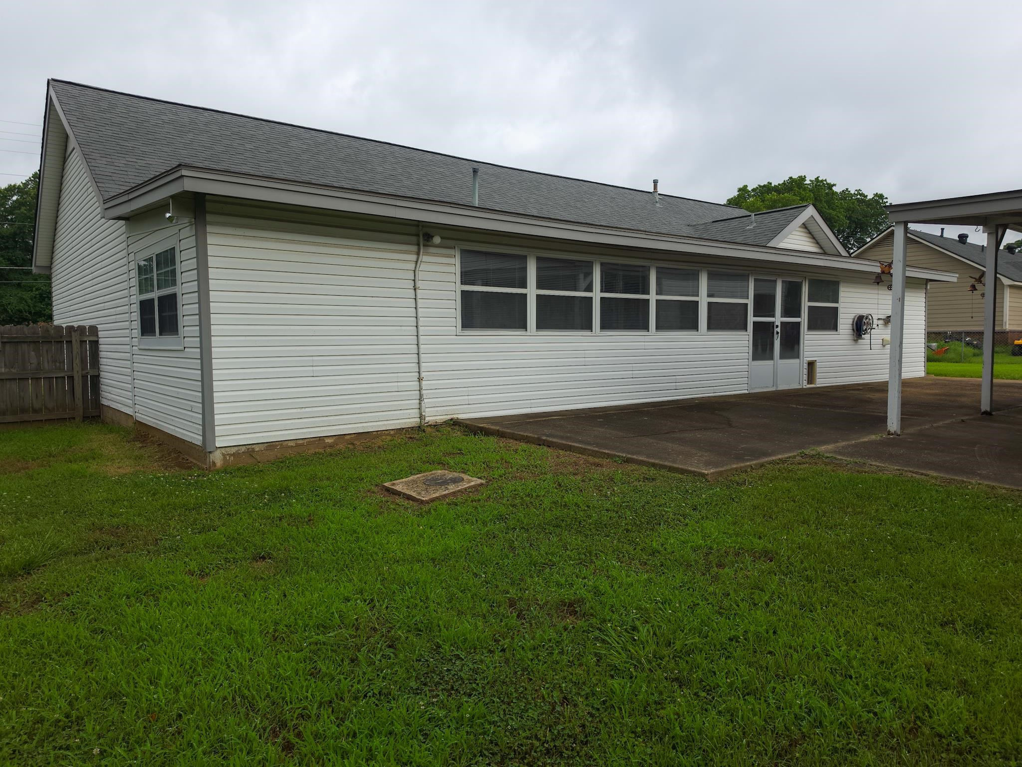 966 Beaver Road Munford, TN 38058 - Photo 30 of 32 Rear exterior with white vinyl siding, a gray shingle roof, a concrete patio, and a covered concrete carport