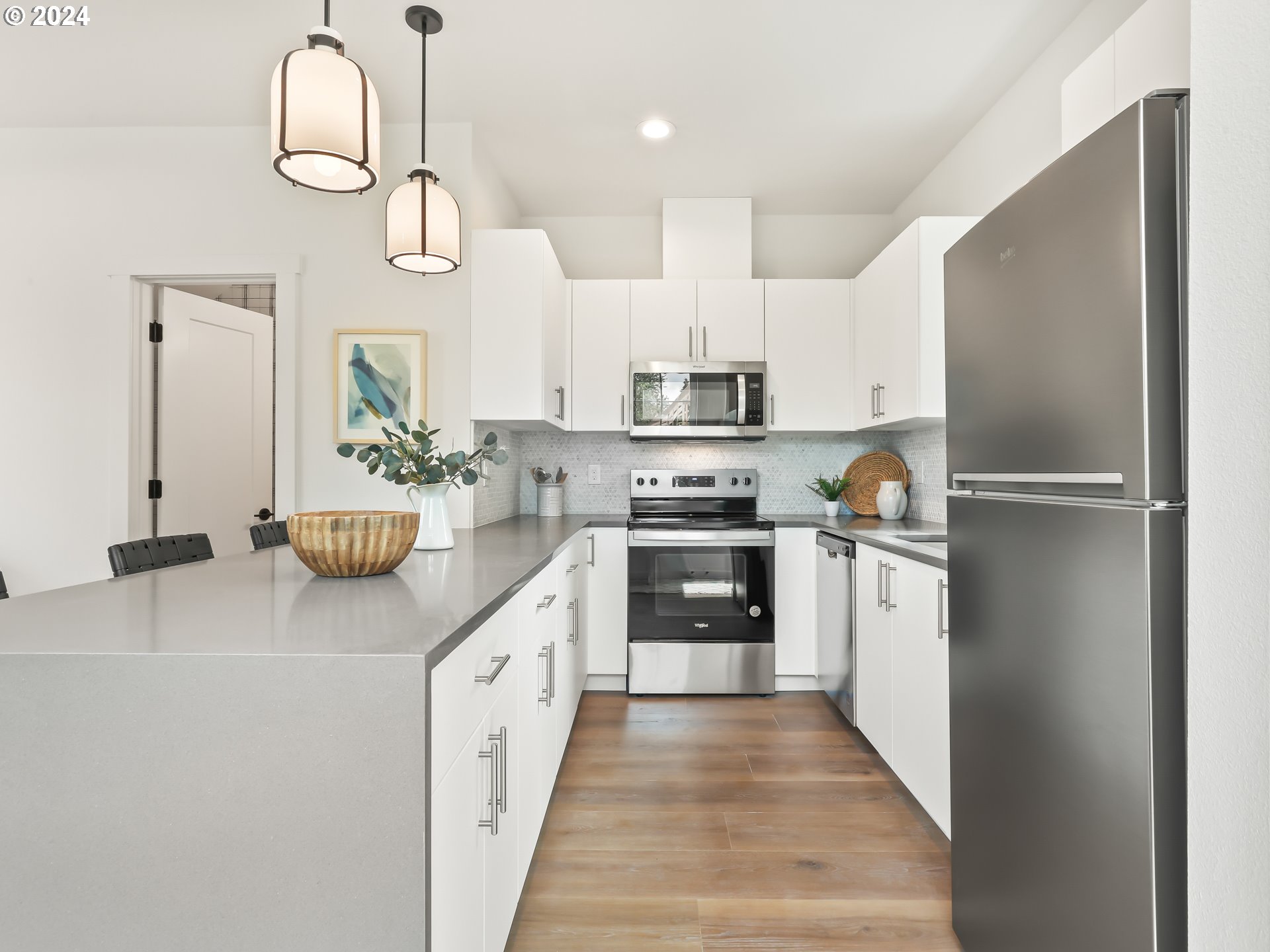4636 Northeast Sumner Street Portland, OR 97218 - Photo 11 of 39 a kitchen with white cabinets and stainless steel appliances