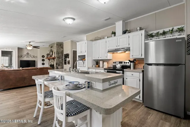 a kitchen with a refrigerator a stove a sink and a dining table