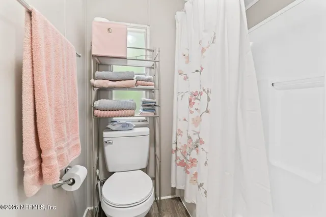 a white toilet sitting next to a shower curtain