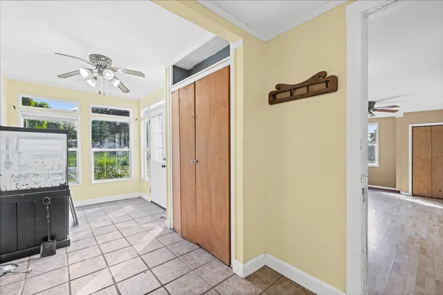a view of a hallway with a chandelier fan and windows