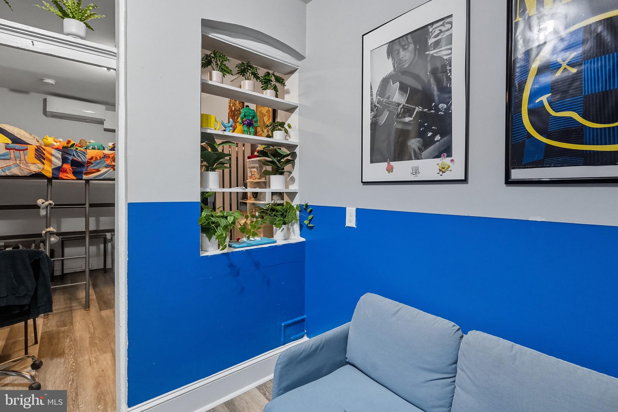 604 East 33rd Street Baltimore, MD 21218 - Photo 13 of 22 a room with painting on the wall and a potted plant