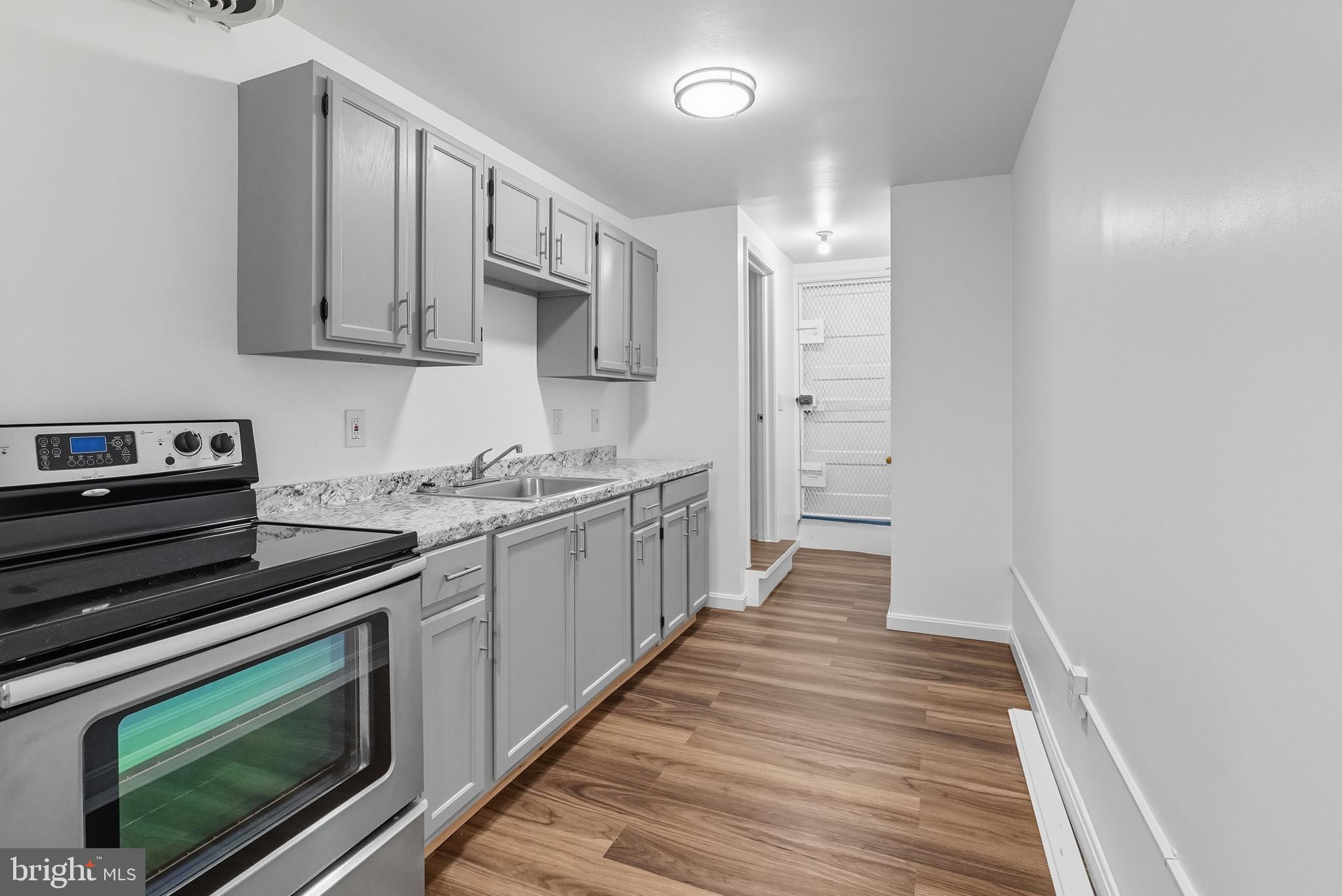 604 East 33rd Street Baltimore, MD 21218 - Photo 18 of 22 a kitchen with stainless steel appliances granite countertop a stove and a sink